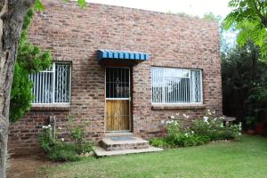 a brick house with a door and a window at The Nook in Cradock