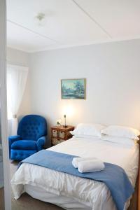 a bedroom with a bed and a blue chair at The Nook in Cradock
