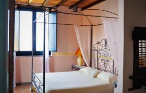 a bedroom with a four poster bed and a window at Marulivo Hotel in Pisciotta