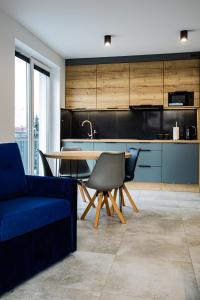 ein Wohnzimmer mit einem blauen Sofa und einem Tisch in der Unterkunft Apart Family in Łeba
