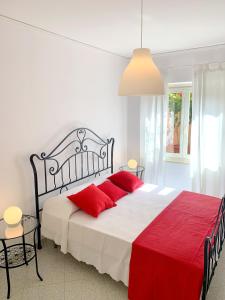 a bedroom with a large bed with red pillows at Piana Apartment in Carloforte