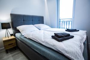 ein Schlafzimmer mit einem Bett, auf dem zwei Handtücher liegen in der Unterkunft Apart Family in Łeba
