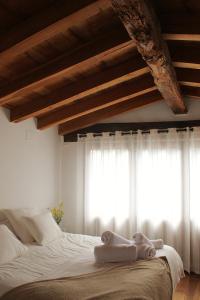 Schlafzimmer mit einem Bett mit weißer Bettwäsche und einem Fenster in der Unterkunft El Niu Casa Rural in Montagut