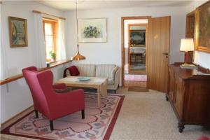 a living room with a couch and a table and chairs at Feriegården i Floutrup in Roslev