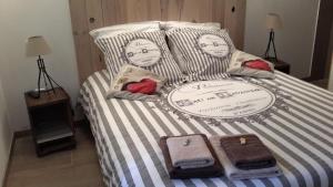 Una cama con sábanas a rayas y toallas. en Les Lavandes d'Estoublon en Estoublon