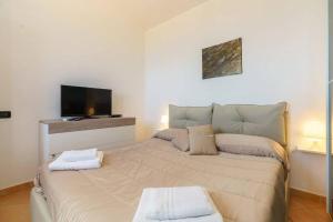 Schlafzimmer mit einem großen Bett und einem Flachbild-TV in der Unterkunft Villa dei Mori in Scopello