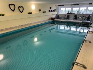 a swimming pool with blue water in a building at Hotel am Wald in Bad Tölz