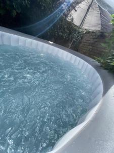 a swimming pool with blue water in a backyard at Canterbury Comfy 6 Bed House with Hot Tub - Entire House in Canterbury