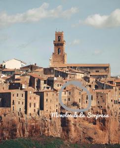 a city on top of a mountain with a clock tower at La Sorpresa Monolocale con VISTA VALLATA in Pitigliano
