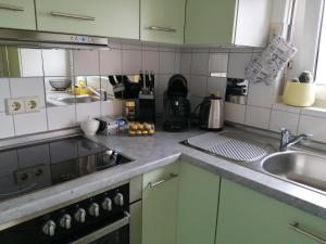a kitchen with a sink and a stove top oven at Schicke 2 Zimmer Wohnung nah an Stuttgart Messe Flughafen in Ostfildern
