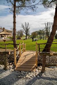 a wooden walkway in a park with a tree at Agriturismo Nonno Mario in Fossone dʼAdige