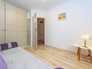 a bedroom with white walls and a purple bed at Nadmorski apartament w lesie in Jantar