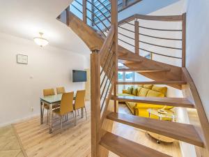 a wooden staircase leading up to a living room and dining room at Nadmorski apartament w lesie in Jantar