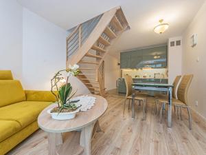 a living room with a yellow couch and a table at Nadmorski apartament w lesie in Jantar
