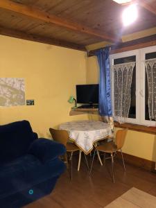 sala de estar con mesa y sofá en Rodzinny Domek Apartament, en Wisłoczek