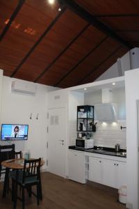 una cocina con armarios blancos, una mesa y una barra en Barbacana, dieciocho, en Baeza