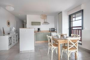 una cucina e una sala da pranzo con tavolo e sedie di Appartement de vacances en Cotes d Armor pour six personnes a Pléneuf-Val-André