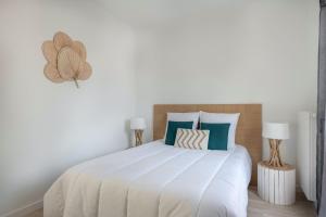 プレヌフ・ヴァル・アンドレにある50m de la plage, bel appartement pour 4の大きな白いベッドと青い枕のある寝室