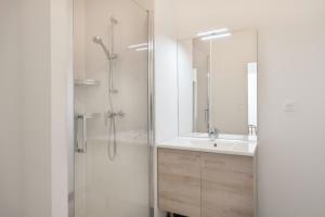 プレヌフ・ヴァル・アンドレにある50m de la plage, bel appartement pour 4のガラスのシャワーと洗面台を備えたバスルーム +11枚の写真