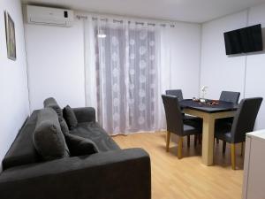 a living room with a couch and a table with chairs at Apartmani Nana Sokobanja in Soko Banja