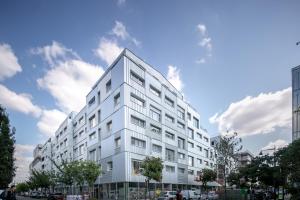 ein weißes Wohnhaus an einer Stadtstraße in der Unterkunft Appart-Hotel Mer & Golf City Ile de Nantes in Nantes