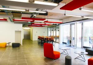 Großes Zimmer mit Stühlen, Tischen und Fenstern in der Unterkunft Appart-Hotel Mer & Golf City Ile de Nantes in Nantes