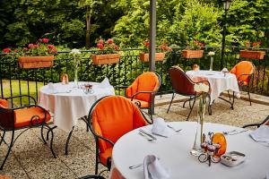 a patio area with tables, chairs and umbrellas at Chateau de Montvillargenne in Gouvieux