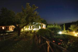 una casa di notte con un albero e una recinzione di Agriturismo La Castellana ad Assisi