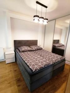 ein Schlafzimmer mit einem großen Bett in einem Zimmer in der Unterkunft Jurajska Plaza - Nowoczesny apartament z osobną sypialnią, Parking GRATIS - HK Apartaments Kielce in Kielce