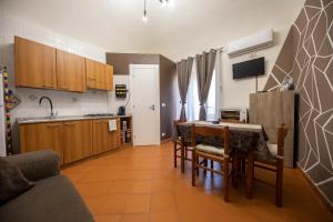 eine Küche mit einem Tisch und Stühlen sowie eine Küche mit einem Waschbecken in der Unterkunft Casa Ruggero in Cefalú