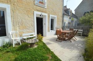 a patio with a table and chairs next to a building at Maison,appartement de charme bord de mer - Avec jardin et wifi in Luc-sur-Mer