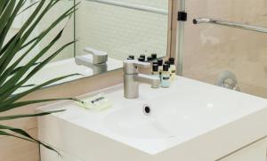 
a white sink sitting under a mirror in a bathroom at Riviere South Beach Hotel in Miami Beach
