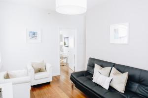 sala de estar con sofá negro y silla blanca en Riviere South Beach Hotel, en Miami Beach