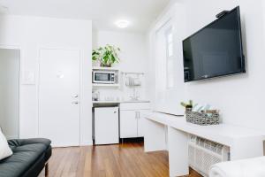 a white kitchen with a desk and a tv on a wall at Riviere South Beach Hotel in Miami Beach