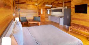 a bedroom with a bed and a kitchen in a cabin at Alma Serrana - Suites de montaña! in La Cumbrecita