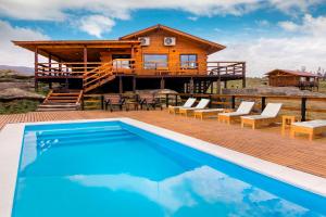 a log cabin with a pool and a house at Alma Serrana - Suites de montaña! in La Cumbrecita