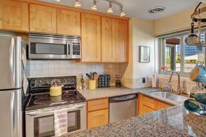 a kitchen with stainless steel appliances and wooden cabinets at Vibrant Downtown, King Bed, Work Desk & Kitchen in Seattle