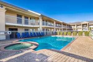 a swimming pool with chairs in front of a building at Americas Best Value Inn New Braunfels in New Braunfels