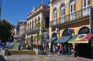 里約熱內盧的住宿－里亞索爾廣場酒店，一群人沿着街道走着,街道上有许多建筑