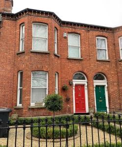 a brick house with a red and green door at Upstairs Studio - Private kitchenette and Small en-suite in Dublin