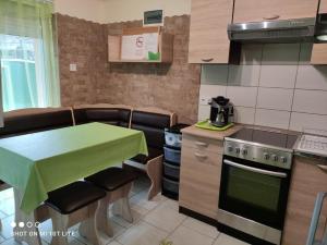 a kitchen with a table and a table and a stove at Napsugár Nyaraló in Tiszaalpár