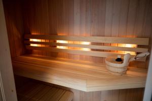 a sauna with a bucket on a wooden shelf at Beach House Makai - family house with Finnish Sauna, 2 bathrooms and only minutes from the Beach in De Koog