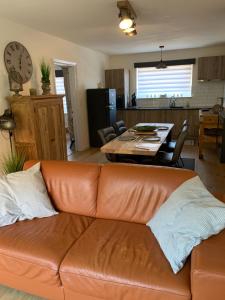 ein Wohnzimmer mit einem Ledersofa und einem Tisch in der Unterkunft Vakantie-appartement LAUREN Westende in Middelkerke