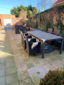 - une table de pique-nique et des chaises sur la terrasse dans l'établissement Vakantie-appartement LAUREN Westende, à Middelkerke