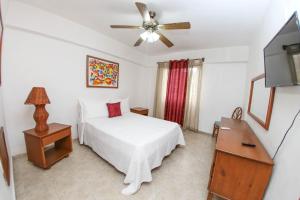 Schlafzimmer mit einem Bett und einem Deckenventilator in der Unterkunft Acuarium Suite Resort in Santo Domingo