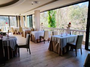 un restaurante con mesas y sillas y un balcón en CAN MARLET MONTSENY Hotel Boutique, en Montseny