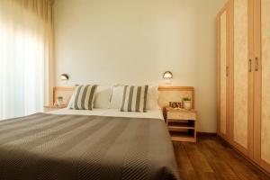 a bedroom with a large bed with striped pillows at Hotel Oceanic in Rimini