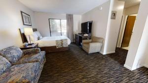 Recreation Inn and Suites في كيلونا: غرفه فندقيه بسرير واريكه