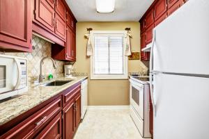 eine Küche mit roten Schränken und einem weißen Kühlschrank in der Unterkunft Shipwatch Pointe I - F316 in Myrtle Beach