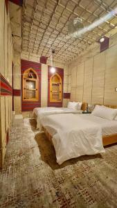 a large room with two large beds in it at Fort Guesthouse نُزل القلعة in Muscat